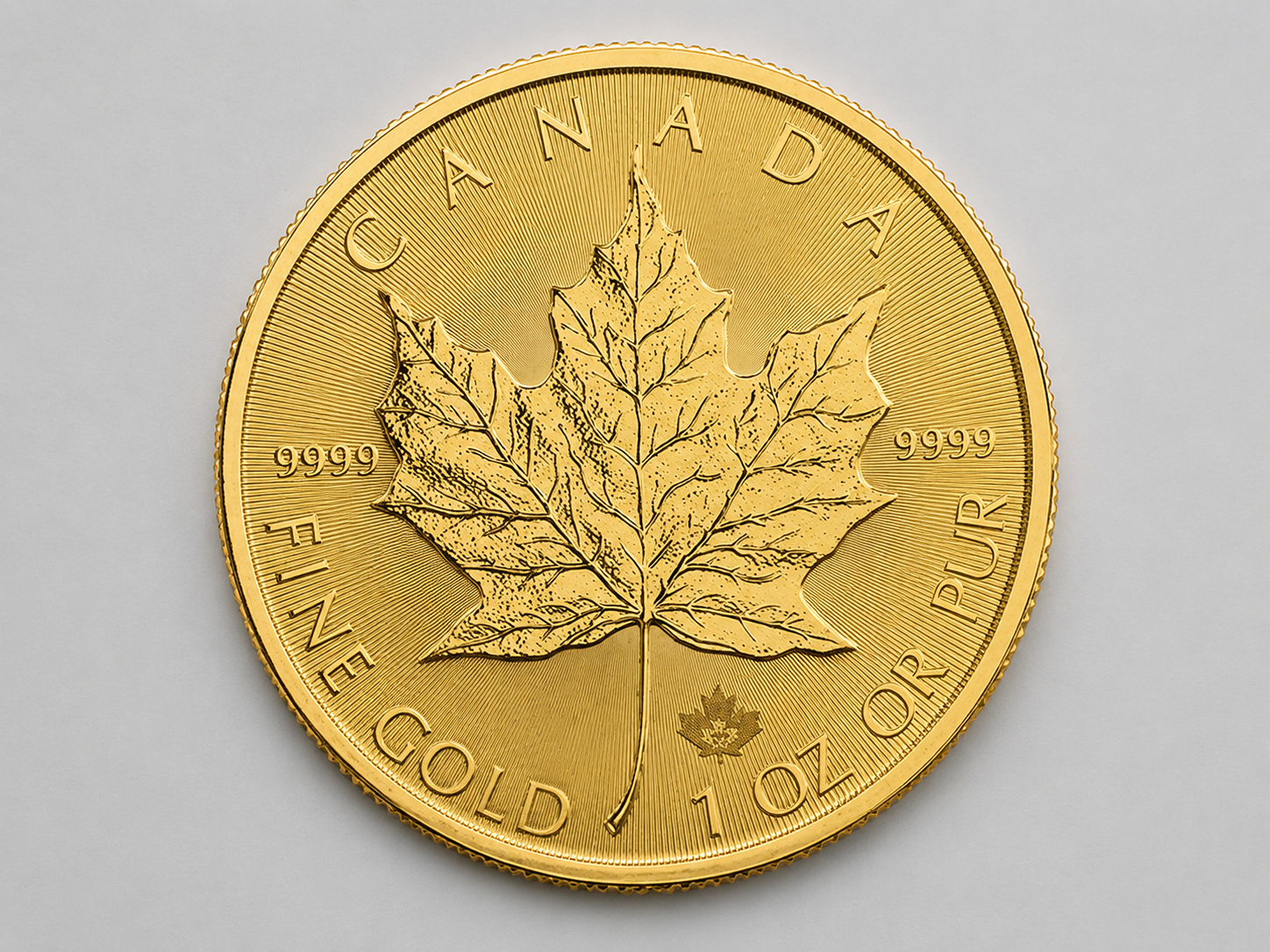 1 troy ounce Canadian Gold Maple Leaf bullion coin, reverse showing the single maple leaf and radial line security feature.