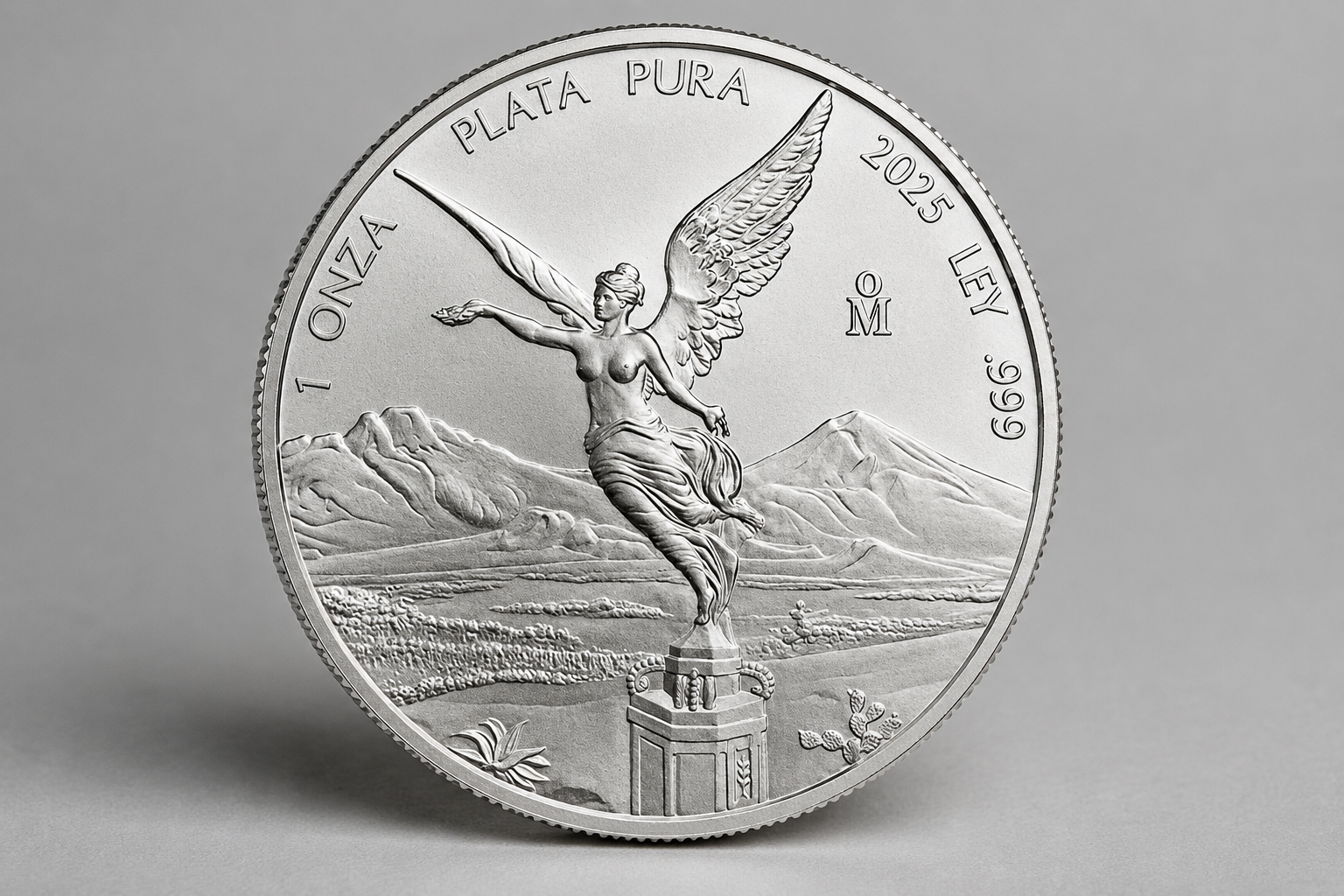 1 troy oz Mexican Silver Libertad bullion coin, reverse showing the Winged Victory statue with Popocatépetl and Iztaccíhuatl volcanoes.