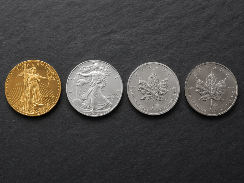 American Gold Eagle, American Silver Eagle, and Canadian Platinum Maple coins arranged on a neutral surface — examples of bullion.